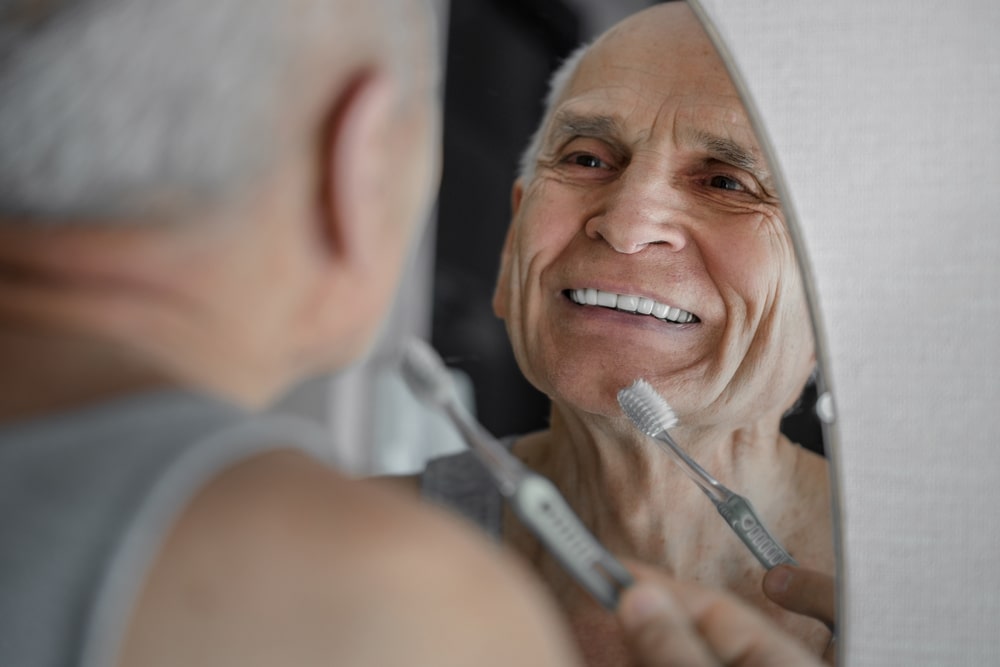 Un homme vieillissant évite la perte dentaire et a un sourire en santé